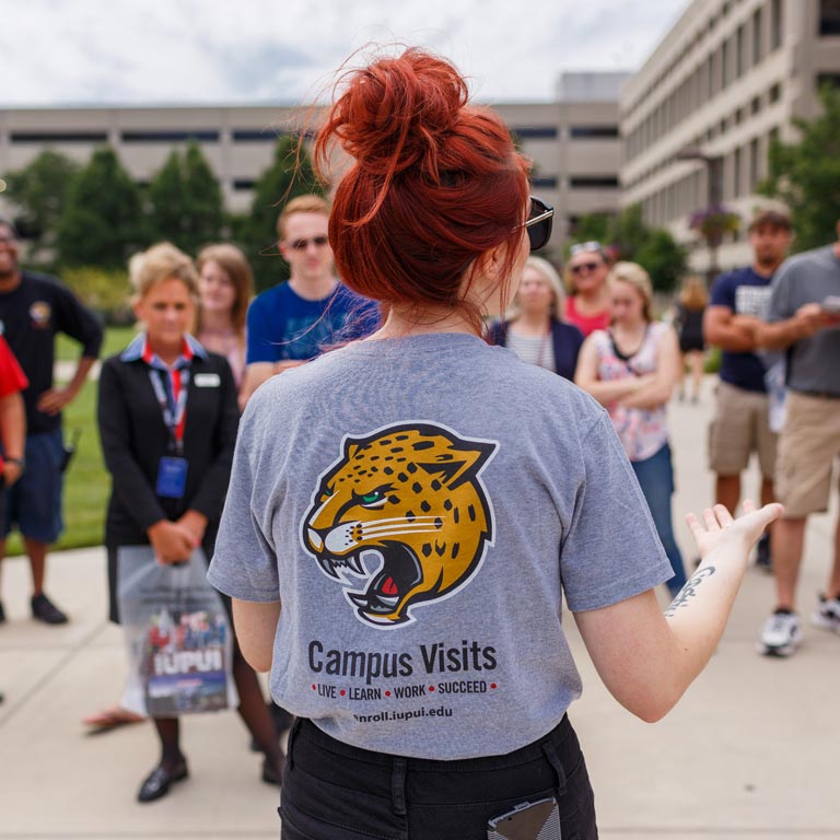 A campus tour guide speaks to a group of students and parents at IUPUI.