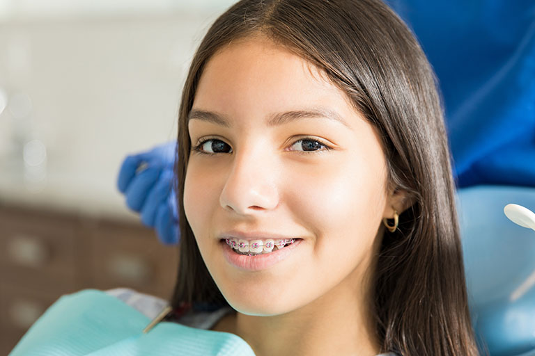a smiling girl wearing orthodontic braces