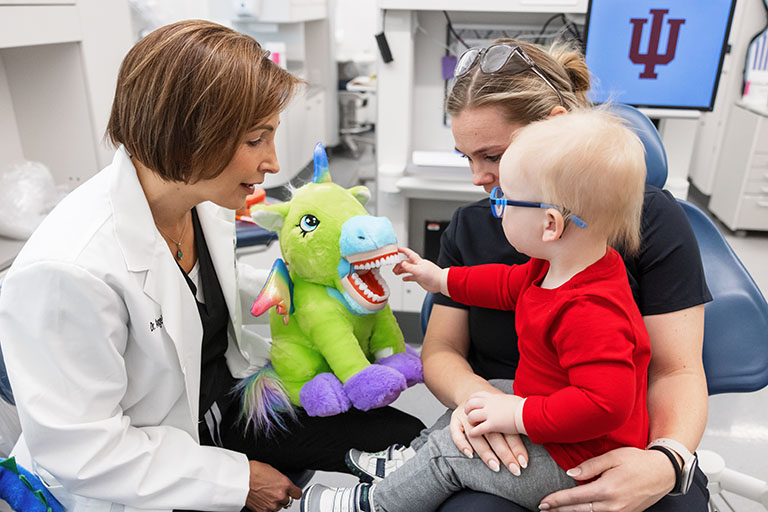 a child with their parent and a dentist